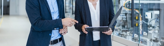 Businessman and businesswoman talking in a modern factory hall