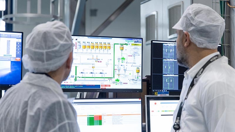 A group of people in white coats looking at a computer screen