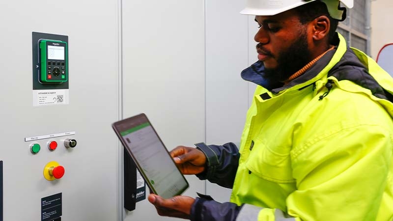 A person in a hard hat using a tablet