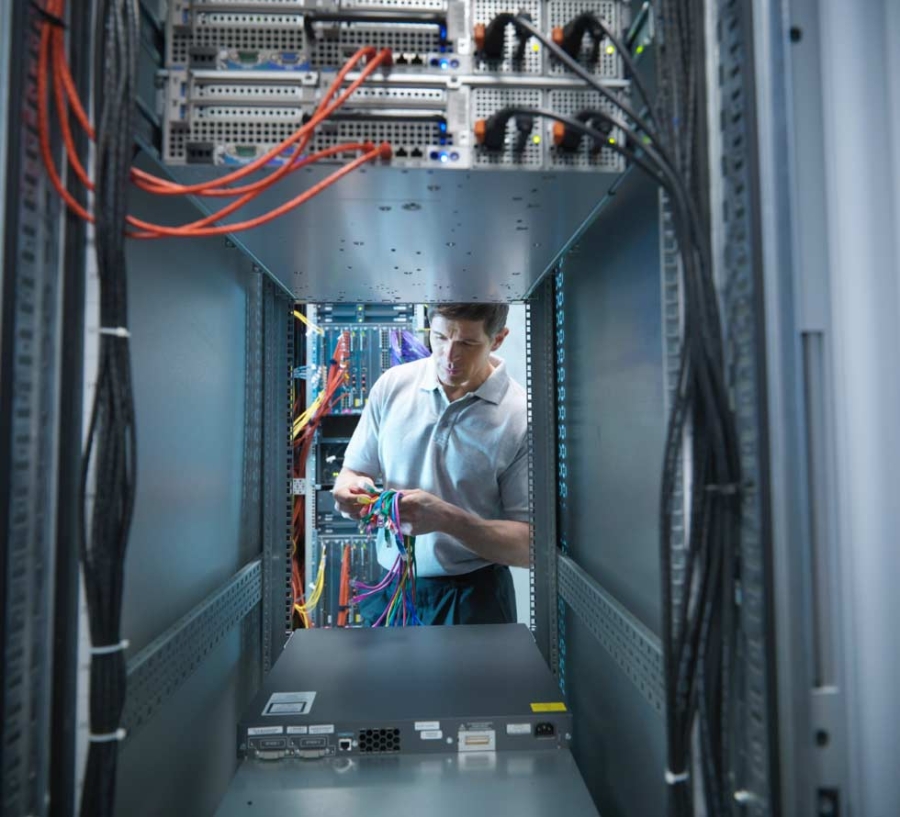 Man inspecting cables in computer server room