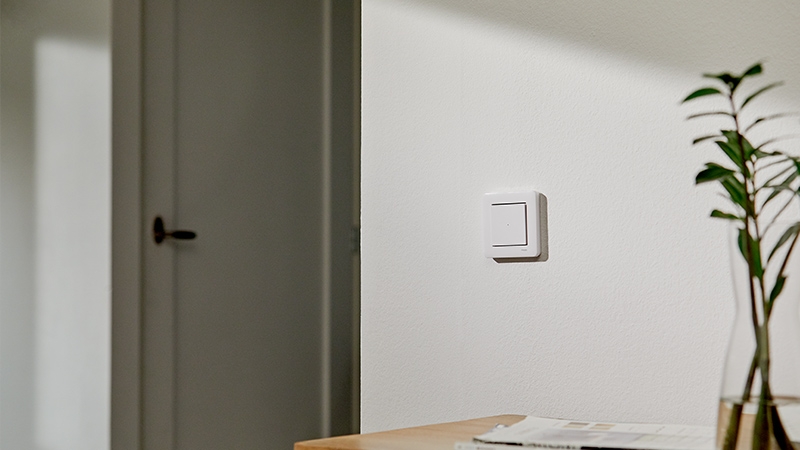 White Exxact switch with Quick Home Connect on white wall door in background