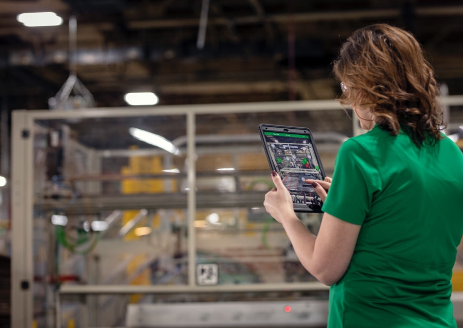 a woman in a green shirt holding a tablet
