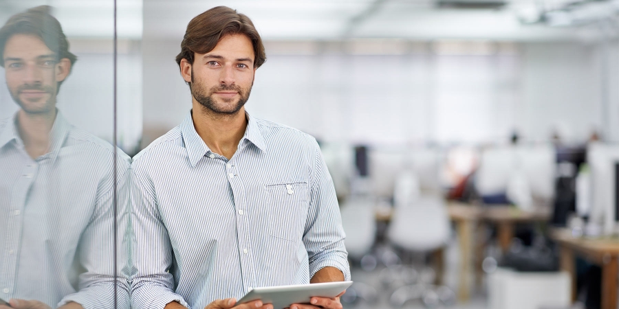 A man holding tablet standing and smiling
