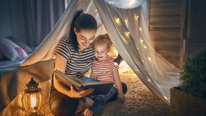a mother and her daughter at home reading a book