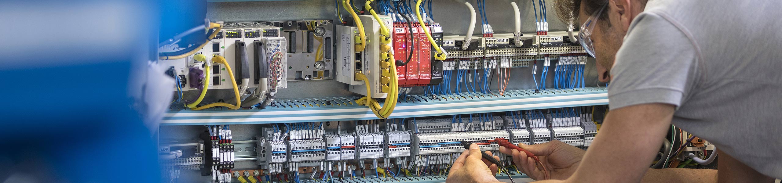 Man testing circuits inside an automation control panel