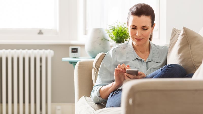 A person sitting on a couch looking at her phone