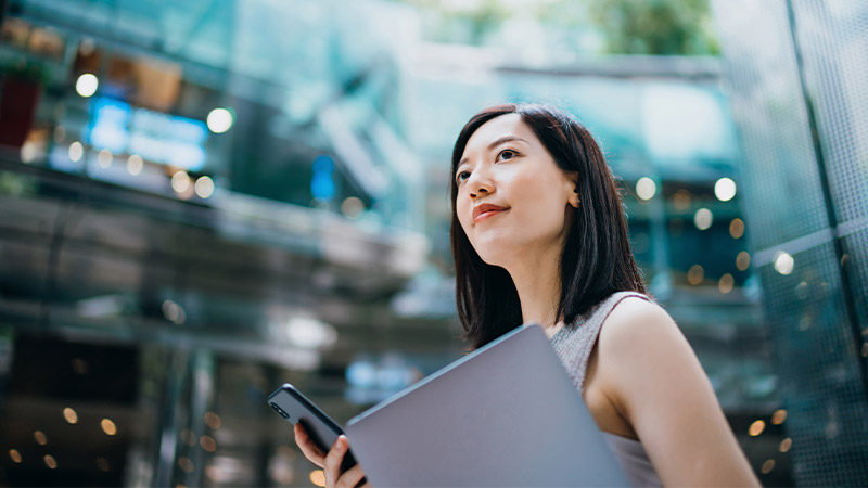 A person holding a computer and a phone