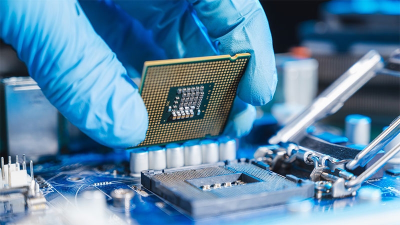 technician laying semiconductor-based CPU in the motherboard socket