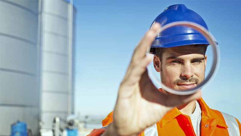 worker looking through metal tube
