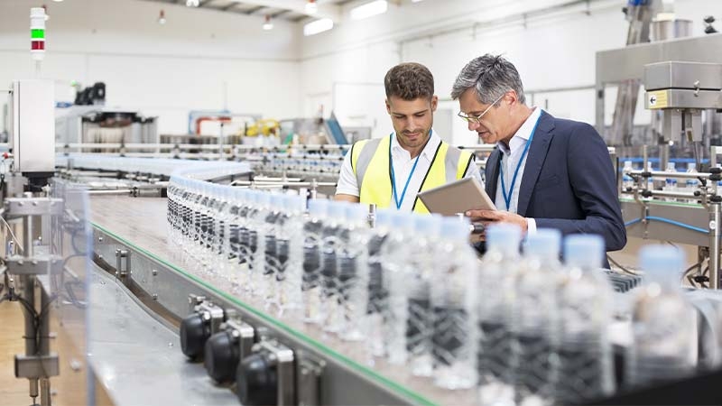 Men in a factory looking at a tablet