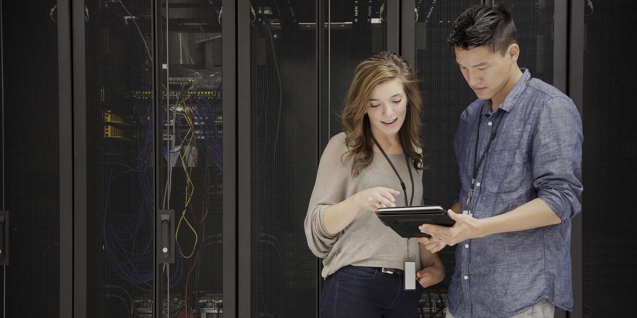 man and woman sharing looking at a digital tablet in the data center