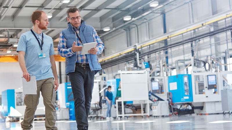 A person and person walking in a factory