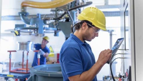 Workers operating environmental testing equipment with digital tablet in electronics factory