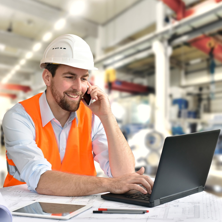 Smiling Engineer talking on phone at industry