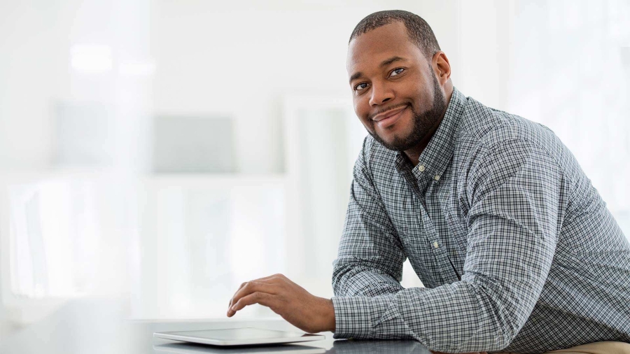 man smiling and using tablet