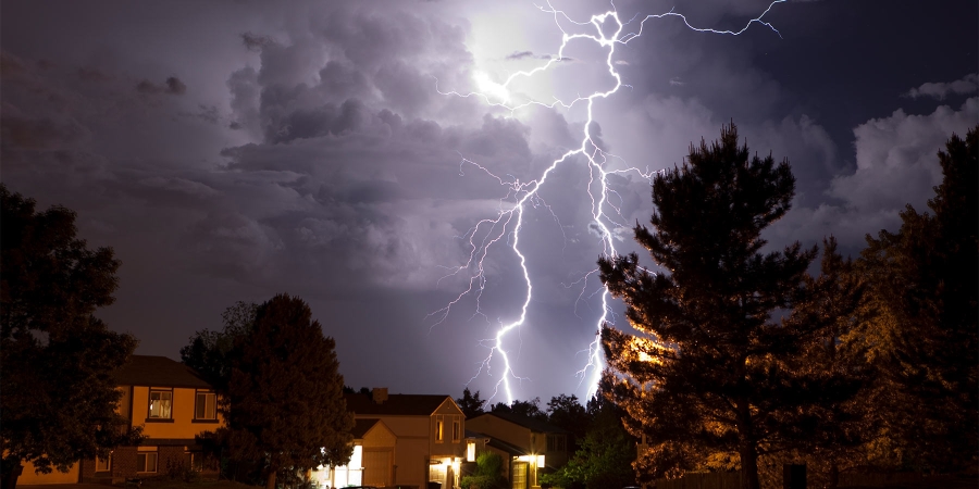 image of a lightning storm over some houses