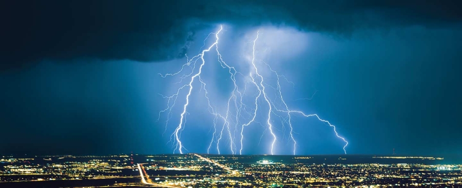 Aerial view of lightning over a city at night, weather.