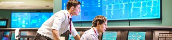Operators in power station control room working with technical challenges, sustainability reporting.