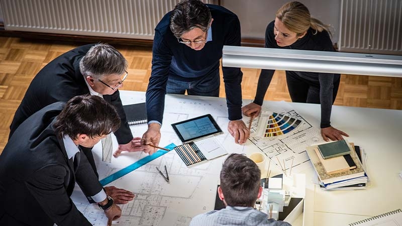A group of people looking at a blueprint