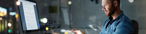 businessman using a computer and digital tablet during a late night at the office
