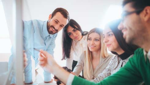 Photo of a young, multi-ethnical team working together in the modern office - consulting each other about some issue while sitting around