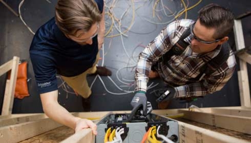 Two electricians working on a circuit breaker