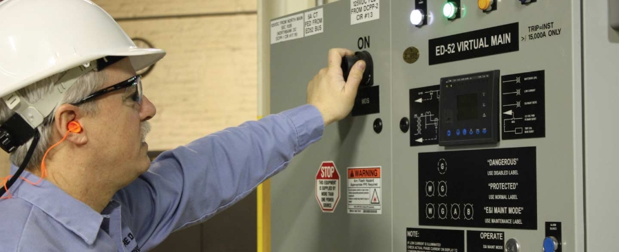 A man with helmet using an electrical box.