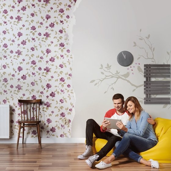 A man and woman sitting on bean bags holding a digital tablet in hand
