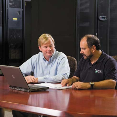 A Schneider Electric employee reviewing paperwork to a man.