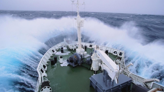 a ship hitting water and spreading mist