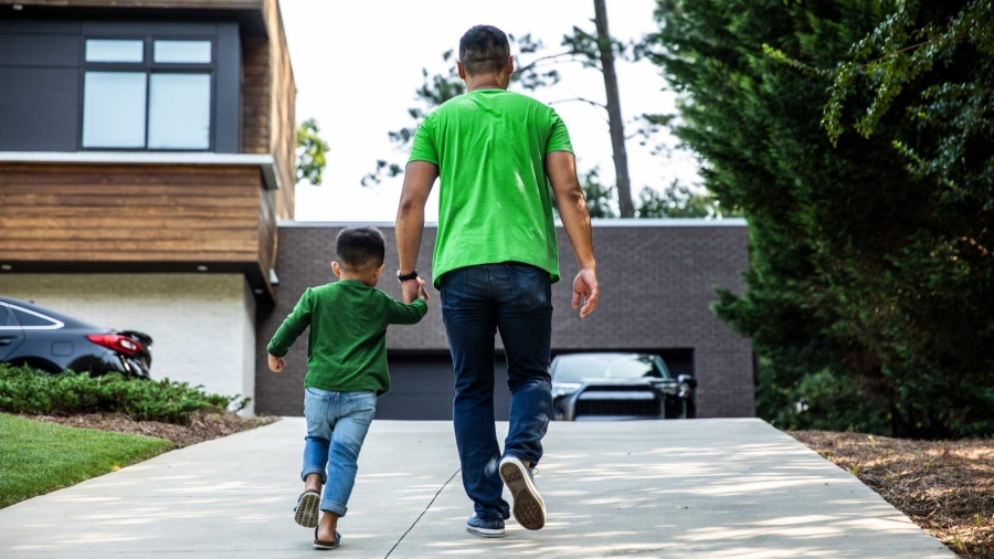 A person and child walking on a sidewalk