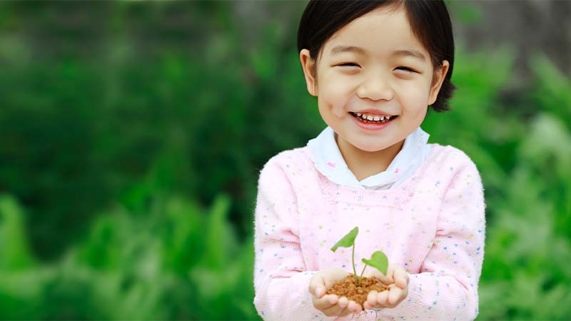 A child holding a small plant