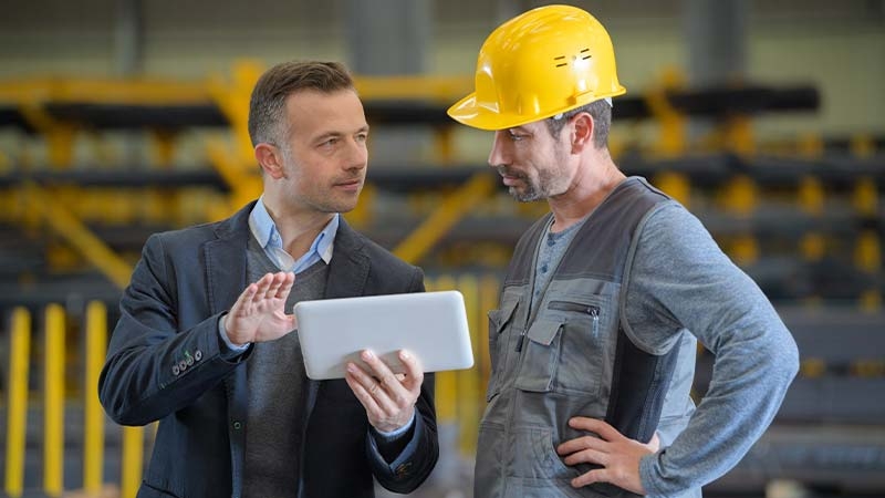 A person in a hard hat talking to a person in a hard hat
