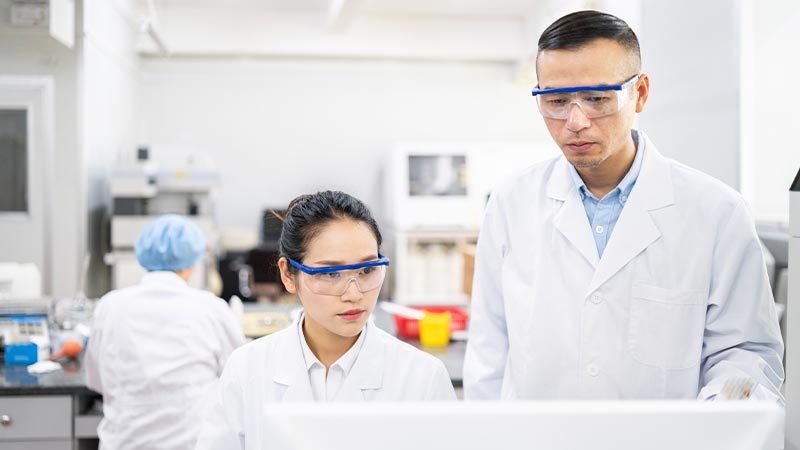 A group of people wearing white lab coats and goggles