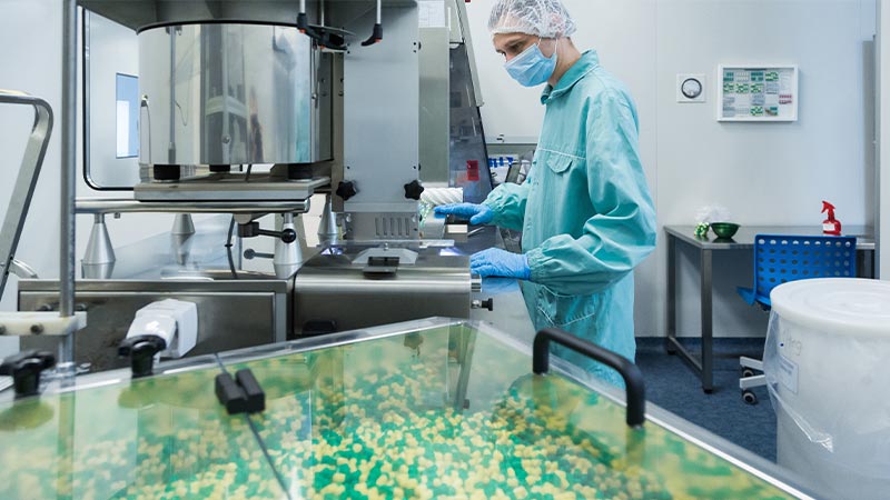 A person in a blue uniform and gloves in a laboratory