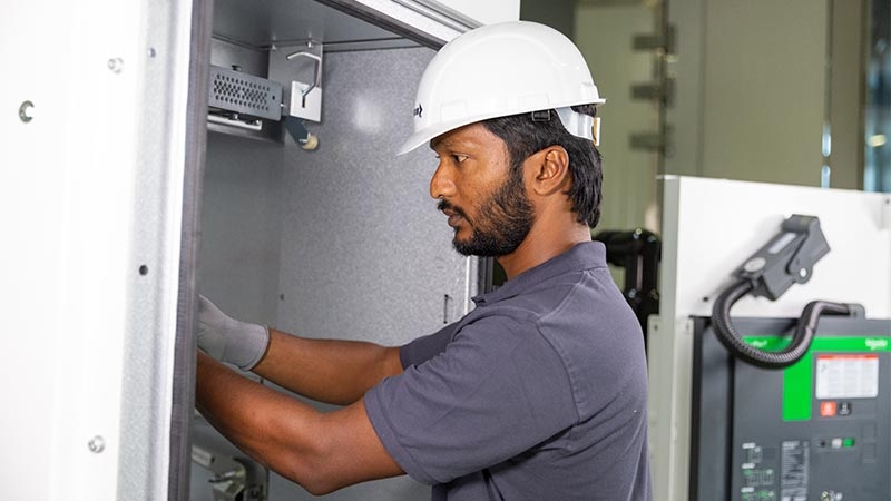 A person wearing a hard hat and gloves