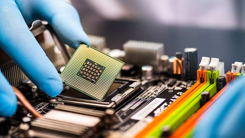 A hand holding a computer chip