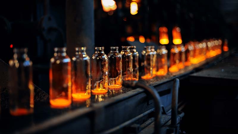 A row of glass bottles with lit candles