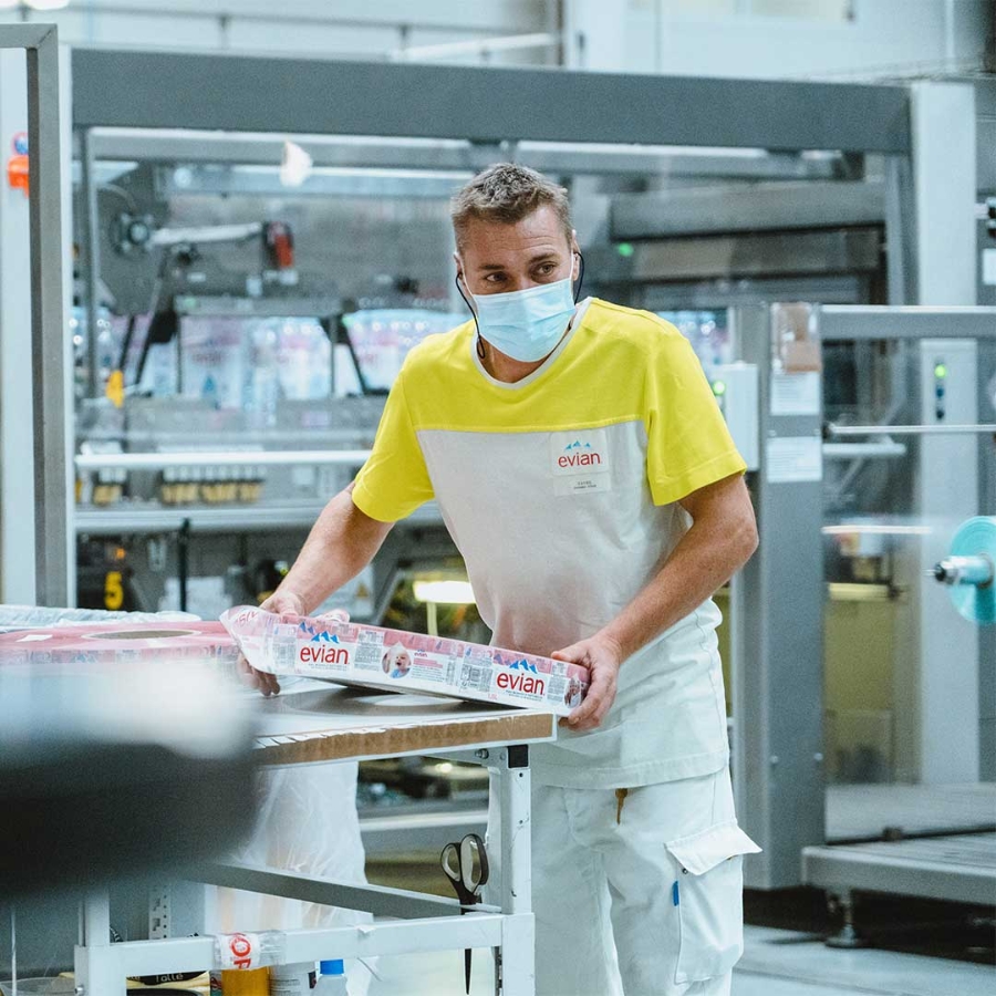A person wearing a mask and working in a factory