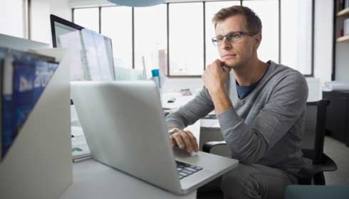 Focused architect working at laptop in office