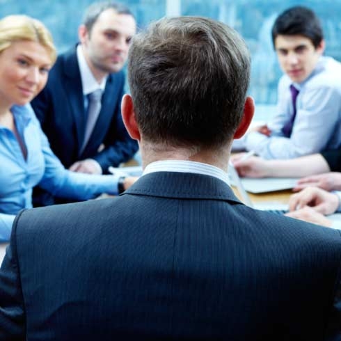 A businessman facing a group of people at a meeting, sustainability consulting.