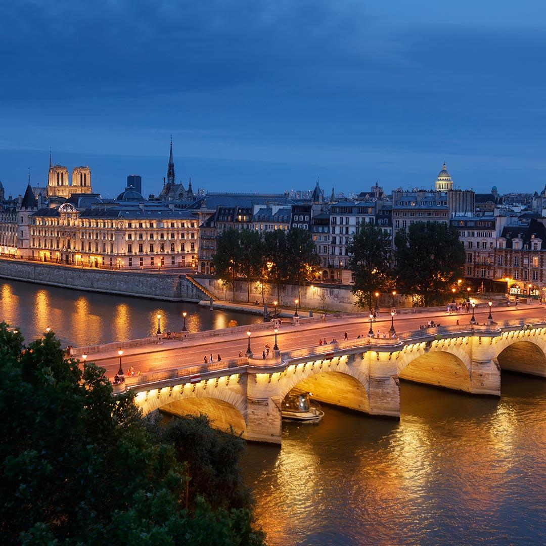  A boat passing under the bridge, European architecture buildings on side, night time