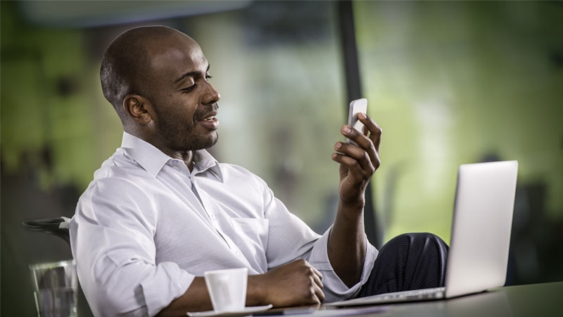 African man watches phone